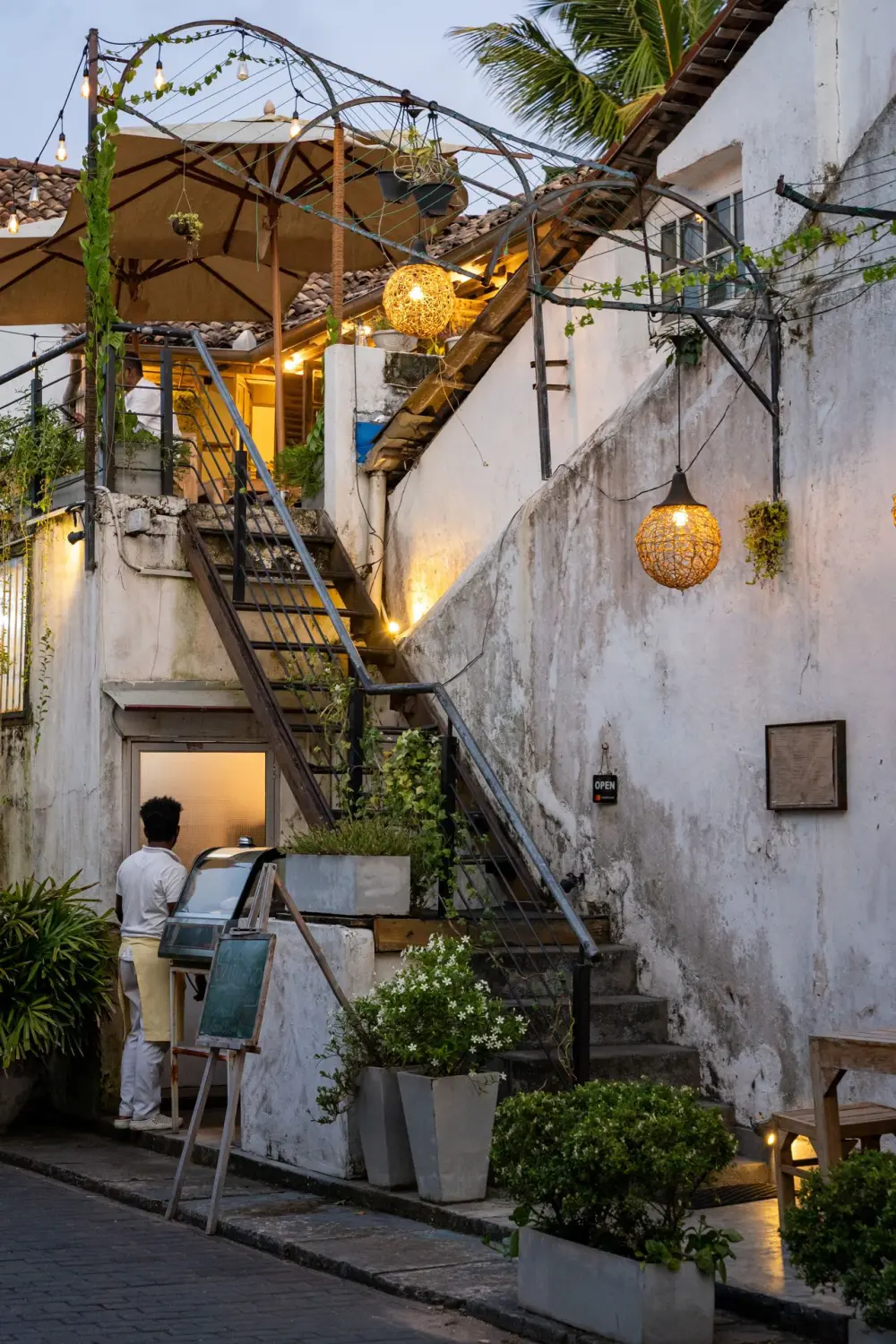 A lantern-lit stairway in a villa courtyard at dusk